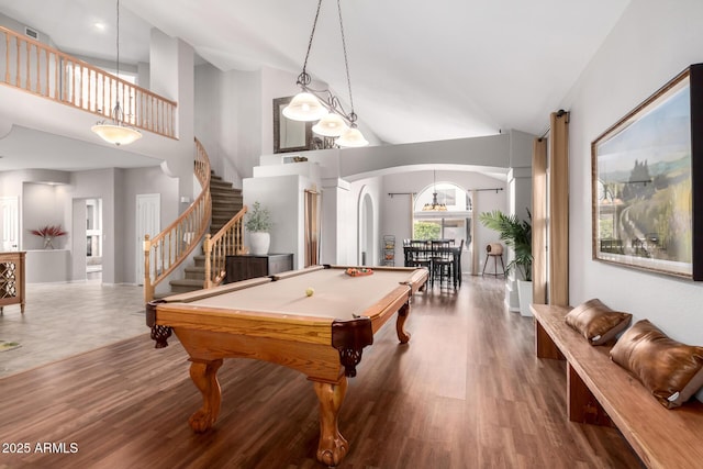 playroom featuring arched walkways, high vaulted ceiling, wood finished floors, and billiards