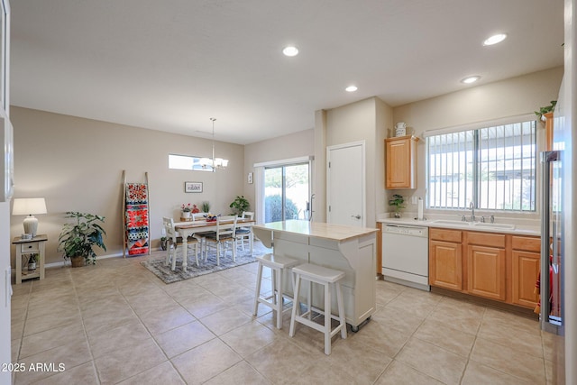 kitchen featuring a kitchen island, pendant lighting, sink, light tile patterned floors, and white dishwasher