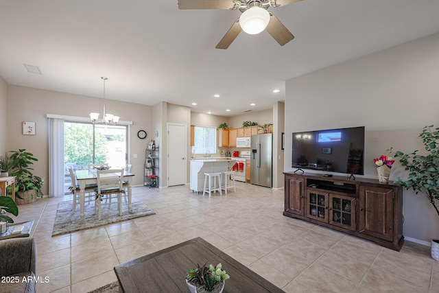 living room featuring ceiling fan with notable chandelier and light tile patterned floors