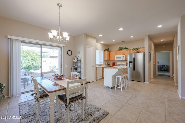 tiled dining area with sink and a chandelier