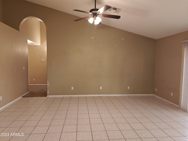 tiled empty room with ceiling fan and vaulted ceiling