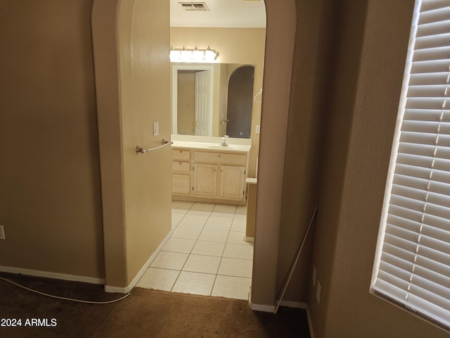 hallway featuring light tile patterned floors and sink