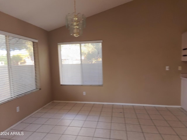 tiled spare room with a chandelier and lofted ceiling