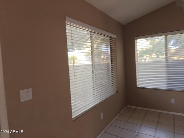 unfurnished room featuring tile patterned floors and vaulted ceiling