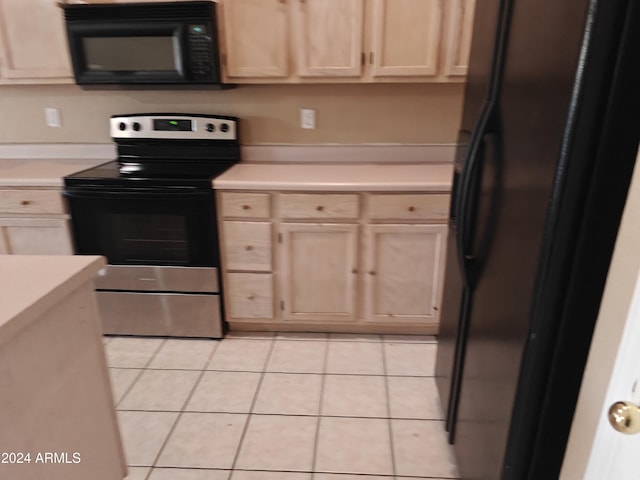 kitchen featuring light brown cabinets, light tile patterned flooring, and black appliances