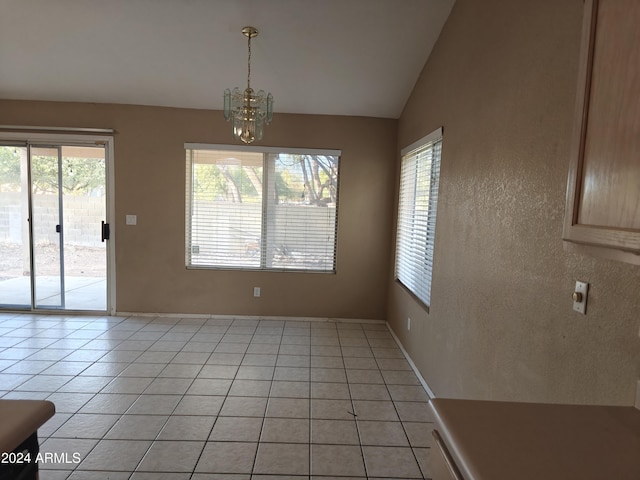 unfurnished dining area with light tile patterned floors, an inviting chandelier, vaulted ceiling, and a healthy amount of sunlight