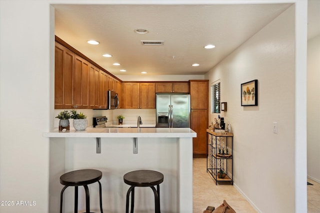 19700 N 76th St Unit 2086, Scottsdale, AZ 85255 - kitchen featuring light countertops, a peninsula, a kitchen bar, appliances with stainless steel finishes, and a sink