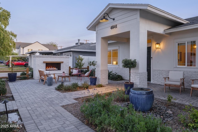 patio terrace at dusk with an outdoor brick fireplace