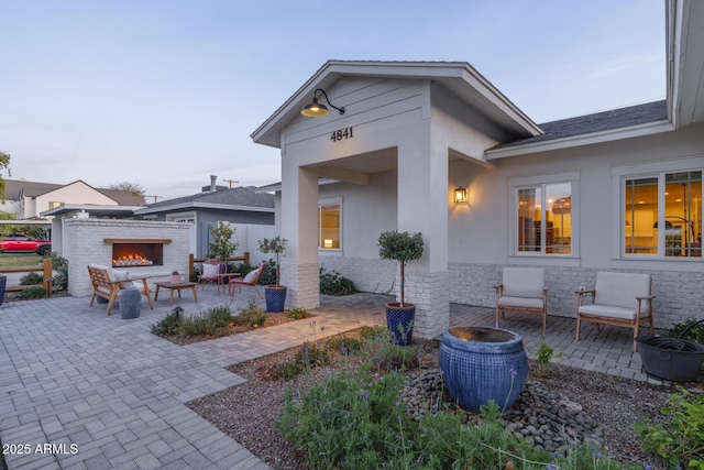 exterior space with an outdoor brick fireplace and a patio area