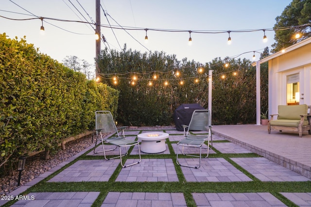 patio terrace at dusk with a grill and an outdoor fire pit