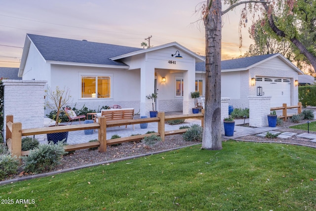 view of front of property with a yard and a garage