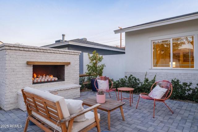 view of patio with an outdoor brick fireplace