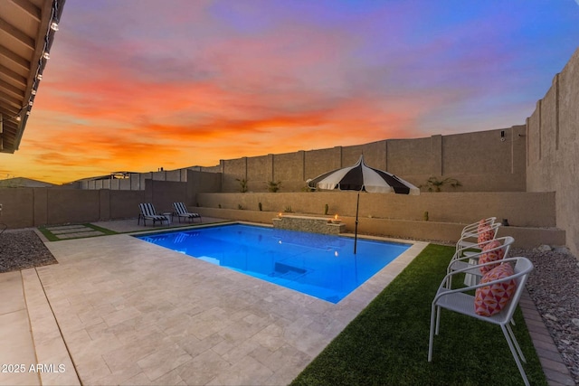 pool at dusk with a patio