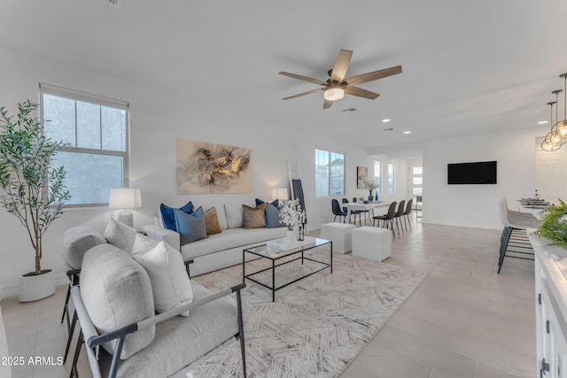 living room featuring light tile patterned floors, plenty of natural light, and ceiling fan