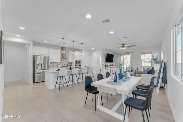 tiled dining space with ceiling fan and sink