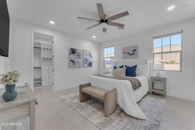 bedroom featuring ceiling fan, a closet, light tile patterned floors, and a spacious closet