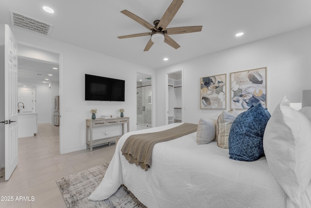 bedroom featuring ensuite bath, ceiling fan, a spacious closet, stainless steel refrigerator, and a closet