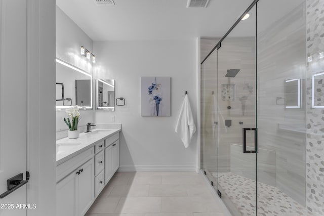 bathroom featuring a shower with door, vanity, and tile patterned flooring