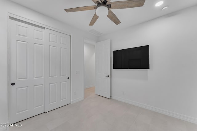 unfurnished bedroom featuring ceiling fan and a closet