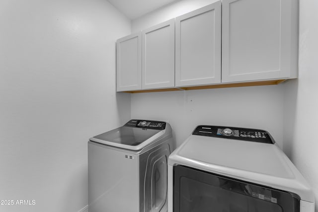 washroom with cabinets and washer and clothes dryer