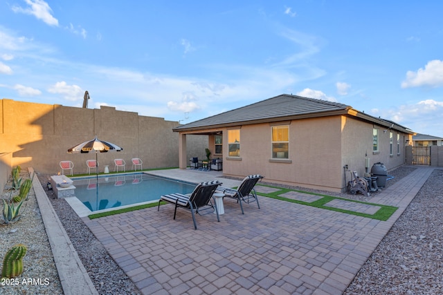 view of pool with area for grilling and a patio