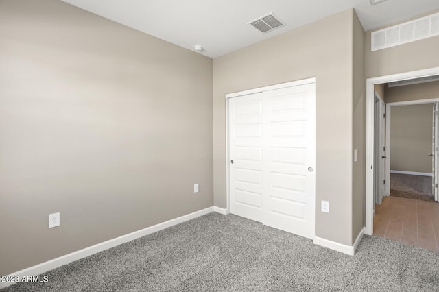 unfurnished bedroom featuring carpet flooring and a closet