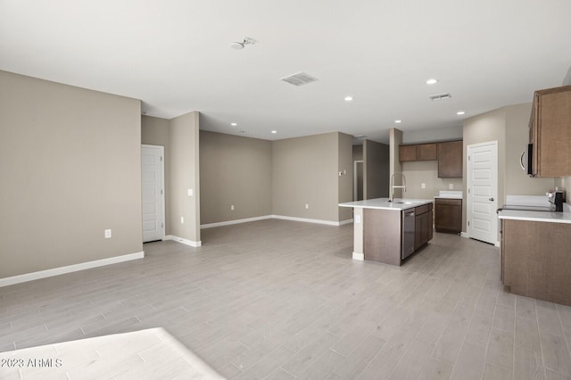 kitchen with sink, an island with sink, light hardwood / wood-style flooring, and appliances with stainless steel finishes