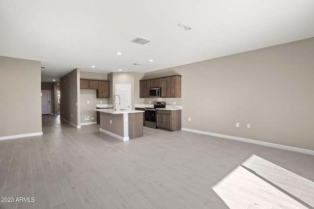 kitchen featuring sink, stainless steel appliances, and a kitchen island with sink