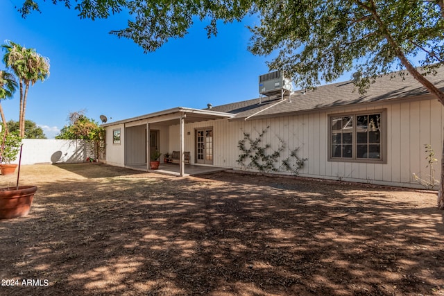 rear view of house with central AC unit and a patio