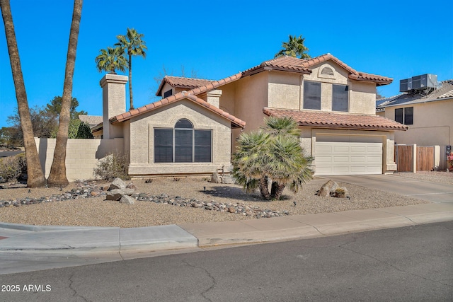 view of front facade with a garage, fence, concrete driveway, and stucco siding