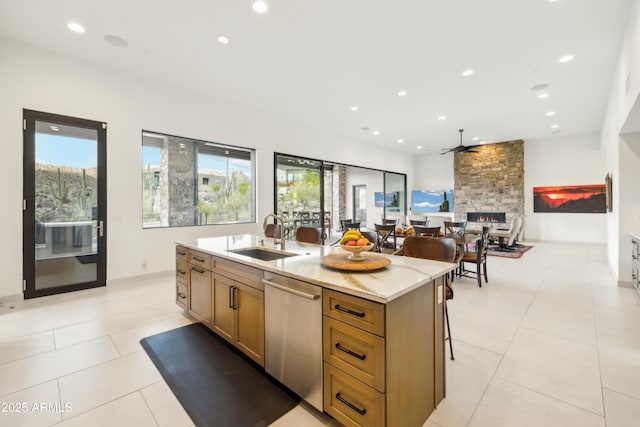 kitchen with a ceiling fan, an island with sink, recessed lighting, a sink, and dishwasher