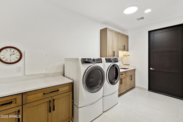 clothes washing area featuring independent washer and dryer, visible vents, cabinet space, a sink, and light tile patterned floors
