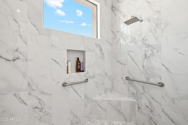 bathroom featuring a marble finish shower