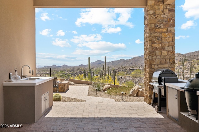 view of patio / terrace featuring a sink, a mountain view, area for grilling, and a grill