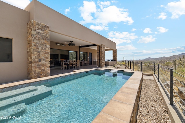 view of swimming pool with fence, a fenced in pool, a patio area, a jacuzzi, and a mountain view