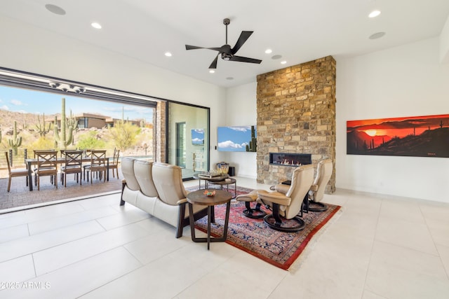 living area featuring tile patterned flooring, a ceiling fan, recessed lighting, and a stone fireplace