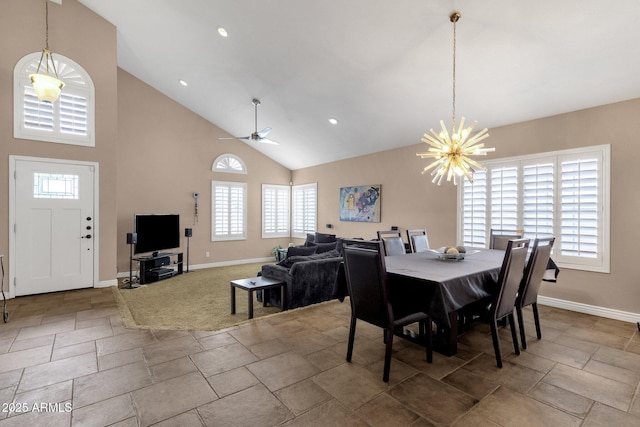 dining area featuring stone tile floors, baseboards, ceiling fan with notable chandelier, high vaulted ceiling, and recessed lighting