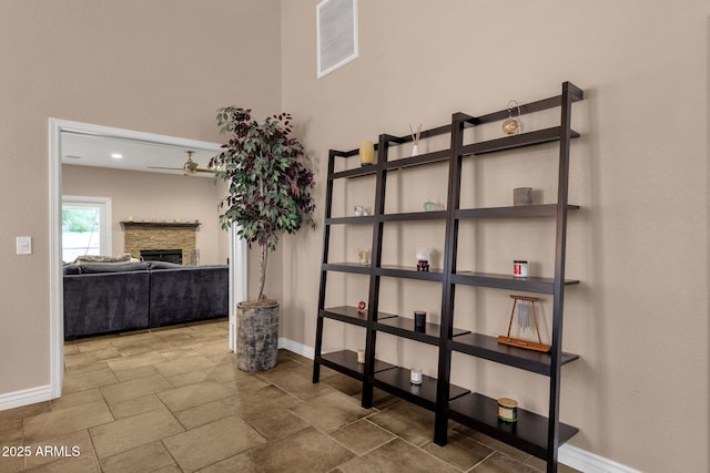 interior space with a towering ceiling, stone finish flooring, and baseboards