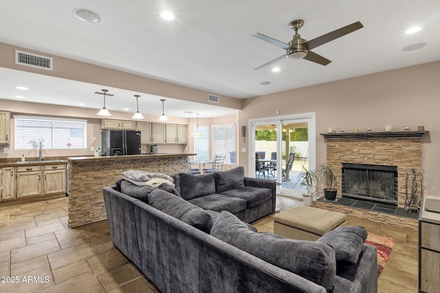 living room with recessed lighting, visible vents, and a fireplace