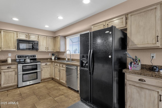 kitchen with tile counters, a sink, black appliances, and light brown cabinetry