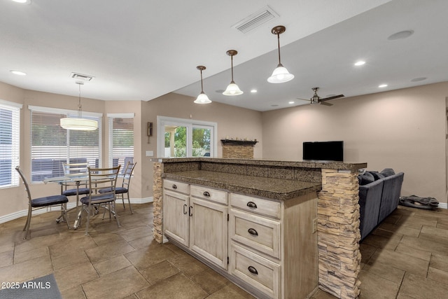 kitchen with decorative light fixtures, dark countertops, visible vents, and baseboards