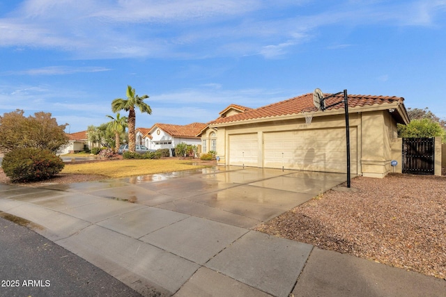 view of front of house featuring a garage, a tile roof, concrete driveway, and stucco siding