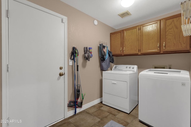 laundry room with cabinet space, baseboards, visible vents, and washing machine and clothes dryer