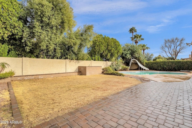 view of home's community with a swimming pool, a patio area, and a fenced backyard