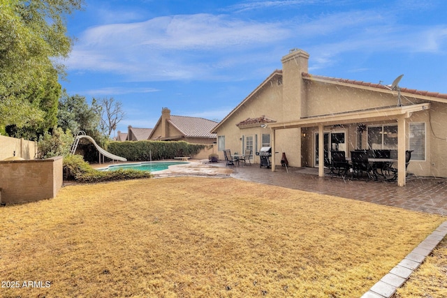 back of house with a patio area, fence, a fenced in pool, and stucco siding