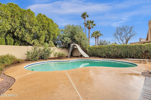 view of pool featuring a fenced in pool, a patio, a water slide, a fenced backyard, and a diving board