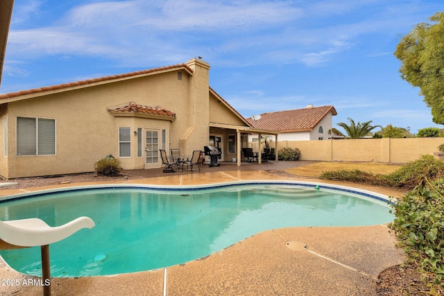 view of swimming pool featuring a fenced in pool, a patio, a fenced backyard, grilling area, and a water slide