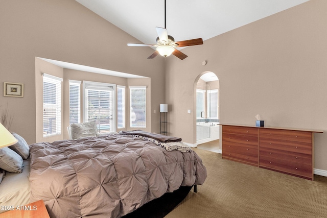 carpeted bedroom with arched walkways, high vaulted ceiling, connected bathroom, a ceiling fan, and baseboards