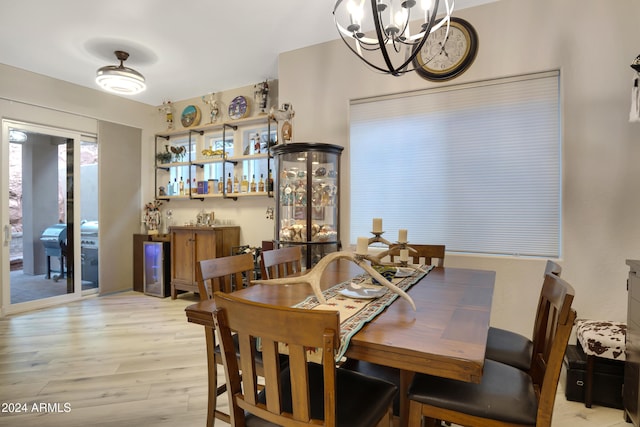 dining room with light hardwood / wood-style flooring and an inviting chandelier