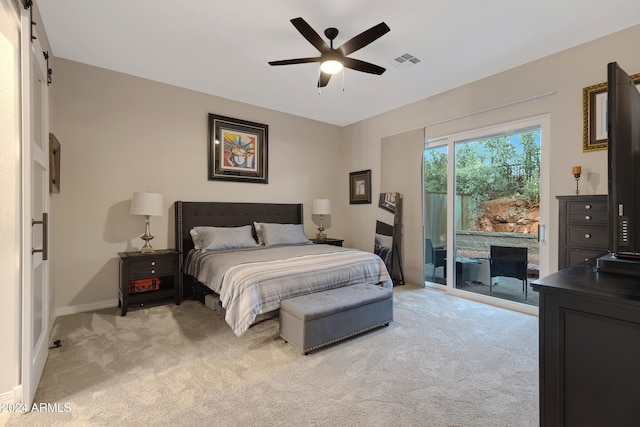 carpeted bedroom featuring access to outside, a barn door, and ceiling fan